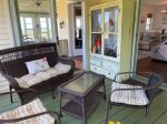 Screened porch seating area with 1890`s wardrobe